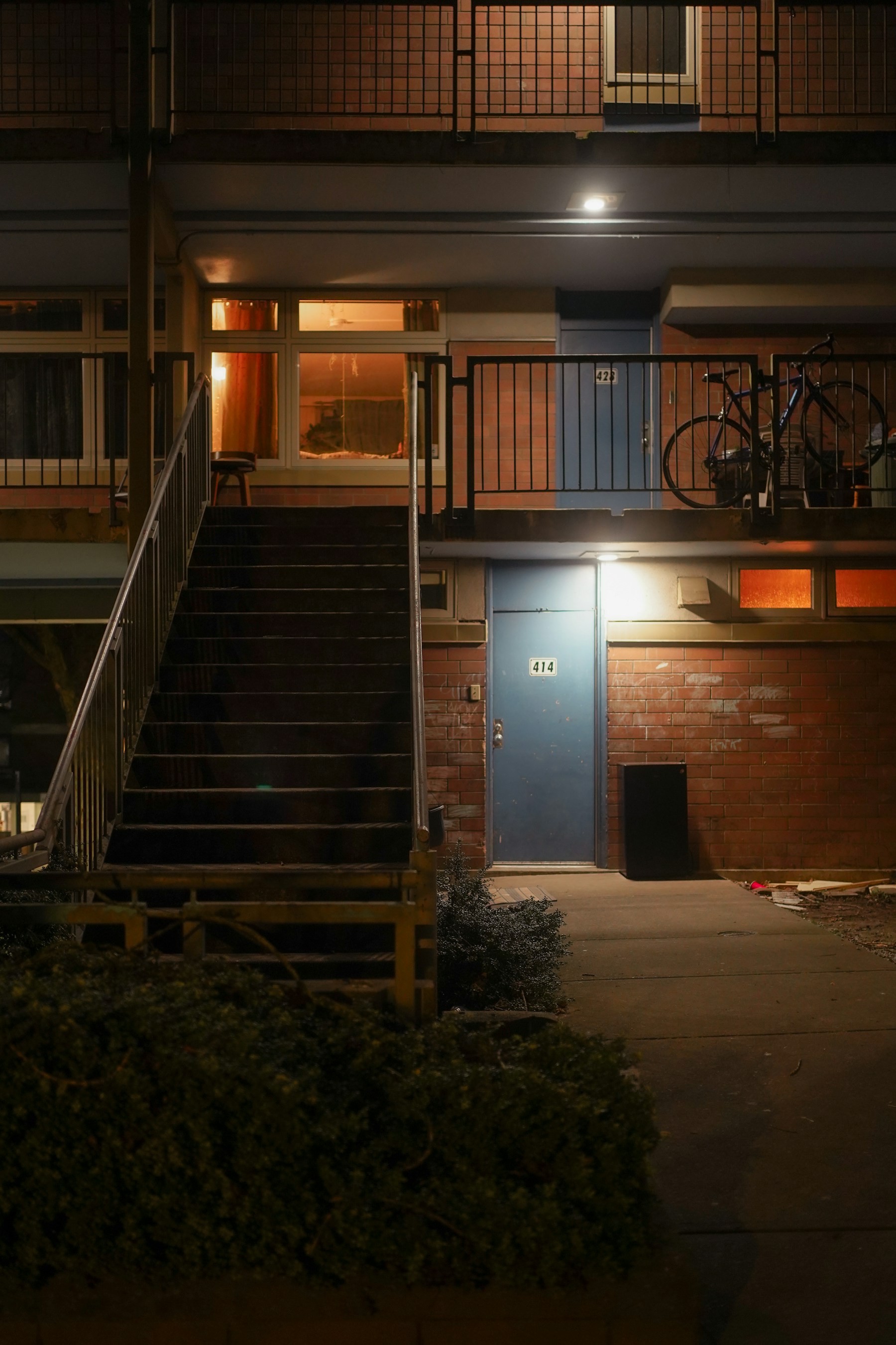 Apartment resident doors and exterior stairways illuminated at night